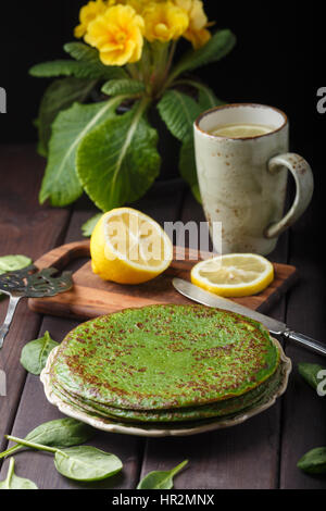 Frittelle di spinaci sul tavolo di legno e giallo primrose. Foto Stock