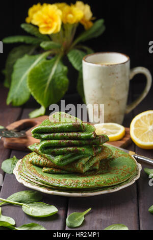 Frittelle di spinaci sul tavolo di legno e giallo primrose. Foto Stock