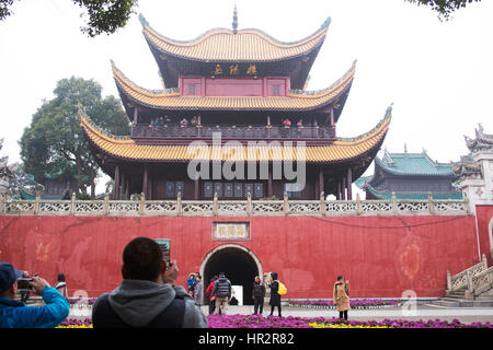 Un turista di fronte alla torre di Yueyang utilizzando i telefoni cellulari. Foto Stock