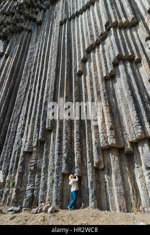 Sinfonia di pietre, Donna sotto le colonne di basalto formazione lungo Garni gorge, provincia di Kotayk, Armenia, Caucaso, Medio Oriente e Asia Foto Stock