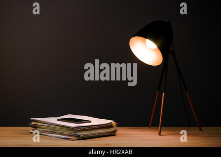 Scrivania con lampada, classificatori e telefono cellulare Foto Stock