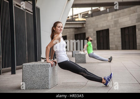 Fitness, sport, esercitando, formazione e concetto di persone - giovane facendo tricipiti dip esercitare sulla strada di città panchina Foto Stock