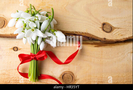 Snowdrops bouquet su un naturale pannello di legno Foto Stock