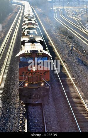 Un eastbound Burlington Northern Santa Fe treno merci facendo un giro e voce in discesa lungo una tre-tack mainline in Aurora, Illinois, Stati Uniti d'America. Foto Stock