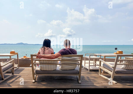 Giovane seduto su un ristorante balcone e terrazza che si affaccia sul mare a Pattaya Thailandia del sud-est asiatico Foto Stock