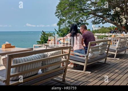 Paio di pranzare in un ristorante balcone e terrazza che si affaccia sul mare a Pattaya Thailandia del sud-est asiatico Foto Stock