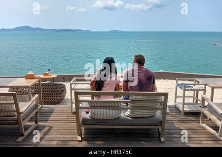 Giovane seduto su un ristorante balcone e terrazza che si affaccia sul mare a Pattaya Thailandia del sud-est asiatico Foto Stock