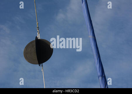 Sfera di ancoraggio in yacht rigging con laminati trinchetta contro un cielo blu con nuvole bianche Foto Stock