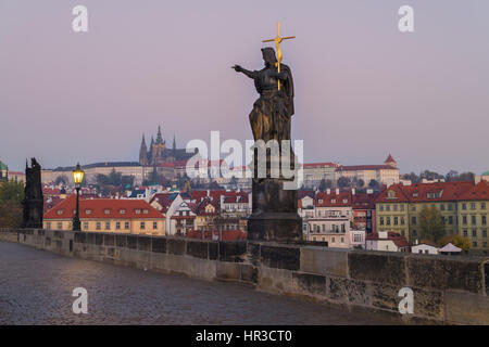 Charles Bridge a sunrise, Praga, Repubblica Ceca. Statua di drammatica e vista sul Castello di Praga e la Cattedrale di San Vito Foto Stock