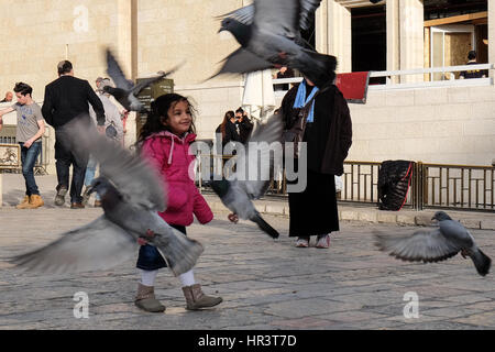Gerusalemme, Israele. Il 27 febbraio, 2017. Una giovane ragazza si disperde piccioni presso il Muro Occidentale sul primo del mese ebraico di Adar. Credito: Nir Alon/Alamy Live News Foto Stock
