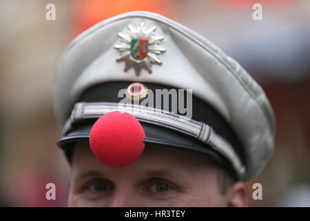 Colonia, Germania. Il 27 febbraio, 2017. Un poliziotto indossa un clown naso sulla sua hat durante il tradizionale lunedì martedì grasso sfilata di carnevale a Colonia, Germania, 27 febbraio 2017. "Wenn mer uns Pänz sinn, peccato mer vun de Söck' (lit. "Quando vediamo i nostri figli, siamo spazzate fuori i nostri piedi") è questo anno il motto del carnevale di Colonia. Foto: Rolf Vennenbernd/dpa/Alamy Live News Foto Stock