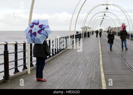 Southport, Merseyside, Regno Unito. Meteo. Il 27 febbraio, 2017. Freddo, umido e ventoso per le persone camminare su di Southport Pier. Febbraio riempire dike essere nero o bianco; ma se è bianco, è il migliore di simili. A dispetto delle condizioni, walkers sul molo sono state sfidando gli elementi per raggiungere la fine della seconda molo più lungo in Inghilterra. Credito: MediaWorldImages/AlamyLiveNews Foto Stock