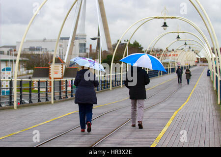 Southport, Merseyside, Regno Unito. Meteo. Il 27 febbraio, 2017. Freddo, umido e ventoso per le persone camminare su di Southport Pier. Febbraio riempire dike essere nero o bianco; ma se è bianco, è il migliore di simili. A dispetto delle condizioni, walkers sul molo sono state sfidando gli elementi per raggiungere la fine della seconda molo più lungo in Inghilterra. Credito: MediaWorldImages/AlamyLiveNews Foto Stock