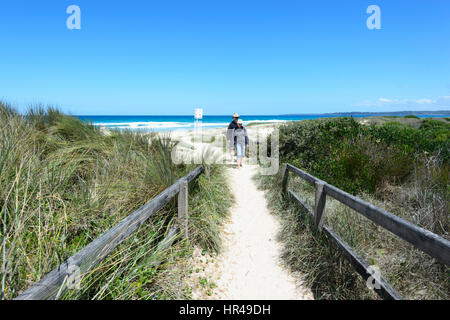 Due persone in cammino sulla via di Conjola Beach, Shoalhaven, South Coast, Nuovo Galles del Sud, NSW, Australia Foto Stock