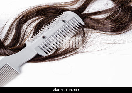 Pettine per capelli slice con lama e i capelli su sfondo bianco. Foto Stock