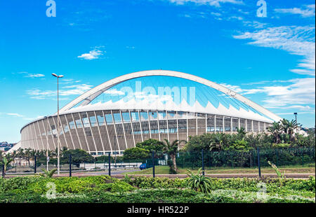 DURBAN, Sud Africa - 24 febbraio 2017: la mattina presto, la vegetazione verde contro Mosè Mabhida Stadium e il blu cielo nuvoloso sfondo in Durban, Sou Foto Stock