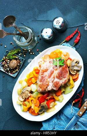 Fritti di carne con verdure sulla piastra e su una tavola Foto Stock