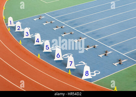 La linea di partenza con i blocchi di partenza per sprint in esecuzione sulla via di un luogo di campo Foto Stock