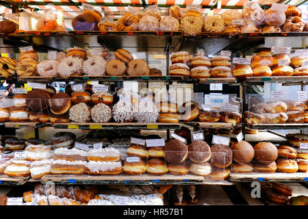 Varietà di ciambelle su un mercato in stallo in una piccola strada di Camden Town, Londra, Regno Unito Foto Stock