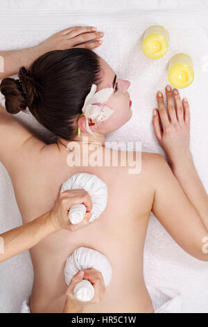 Thai massaggio a sfera. Donna getting SPA tailandese alle erbe comprimere massaggio. Vista superiore Foto Stock