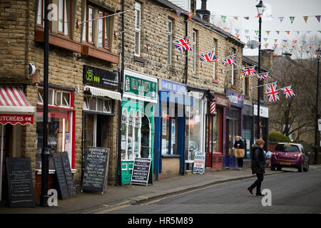 Bunting e bandiere su Hare Hill Road, ,Littleborough Borgo in pietra negozi terrazzati, Rochdale, Lancashire, Inghilterra, Regno Unito. Foto Stock