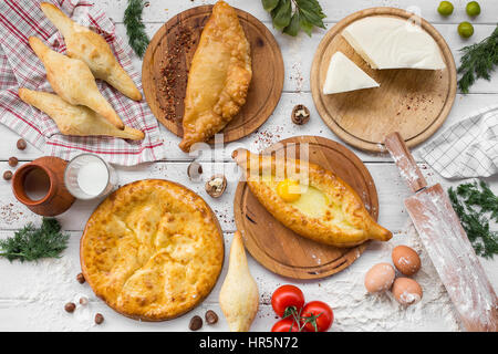 Tradizionale georgiano adjara khachapuri e Kolkh khachapuri sul tavolo. In casa la cottura. Vista dall'alto. Lay piatto Foto Stock