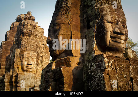 Giant volti sorridenti scolpiti nella pietra presso il tempio Bayon in Angkor Thom complessa, Cambogia. Foto Stock