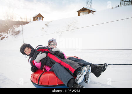 Madre e figlio su un tubo di neve, a bellezza giornata invernale Foto Stock