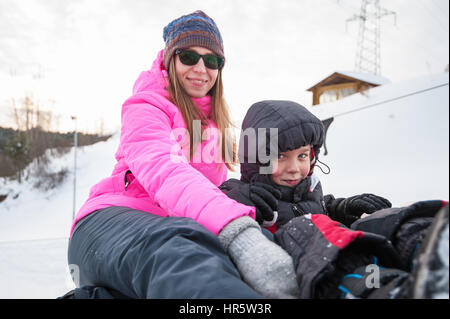 Madre e figlio su un tubo di neve, a bellezza giornata invernale Foto Stock