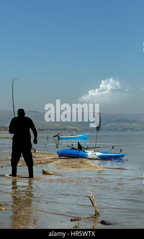 Pescatore pescato una grande carpa sul mare di Galilea Foto Stock