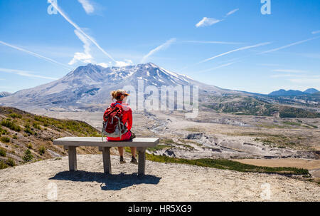 Una donna escursionista tenendo a riposo su una panchina lungo il Johnston Ridge Trail nel Monte Sant Helens nazionale parco vulcanico, Washington, Stati Uniti d'America. Foto Stock