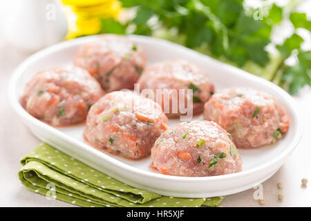 Materie polpette di carne sulla piastra bianca, cottura in cucina Foto Stock