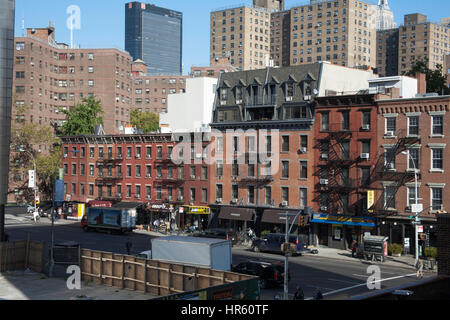 Negozi e tradizionali edifici di appartamenti in corrispondenza della giunzione di 10th Avenue e West 25th Street dalla linea alta Manhattan New York City USA Foto Stock