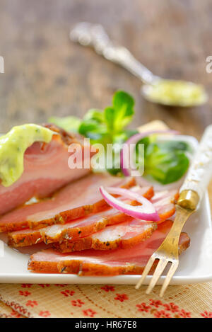 La pancetta affumicata e le verdure sul tavolo di legno Foto Stock