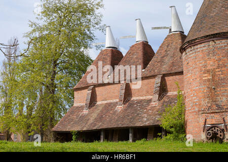 Tradizionale in rosso mattone oast house nelle zone rurali del sud-est dell' Inghilterra su una giornata di primavera . Foto Stock