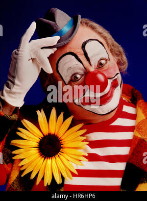 Clown poster circo colorato costume tradizionale con il naso rosso in posa per una fotografia in studio per promuovere tramite POS concessionario poster display negativo Kodak color film degli anni settanta /ottanta Ian Shaw fotografo Kodak Foto Stock