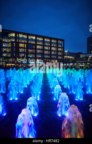 Il centro città di Manchester Piccadilly Gardens landmark fontana di acqua il display si illumina di notte. Foto Stock