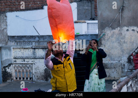 Jaipur, India - 14 Gennaio 2017 : Lancio della famiglia di una lanterna di carta dal loro tetto durante il festival di Makar Sankranti Uttarayan in Rajasthan Foto Stock