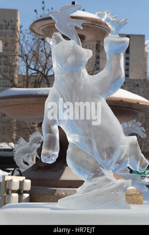 Sculture di ghiaccio a Ottawa, in una giornata di sole con edifici della città dietro. Scupltrure di ghiaccio è di un orso con un uccello sulla testa Foto Stock