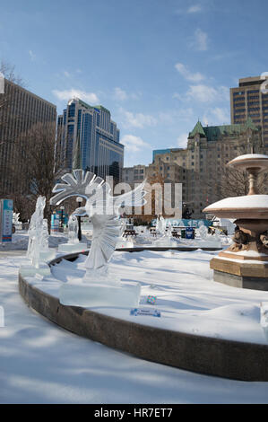 Sculture di ghiaccio a Ottawa, in una giornata di sole con edifici della città dietro. Il carving è di un grande rapace, una cornacchia, falco o aquila con ali outstreched Foto Stock