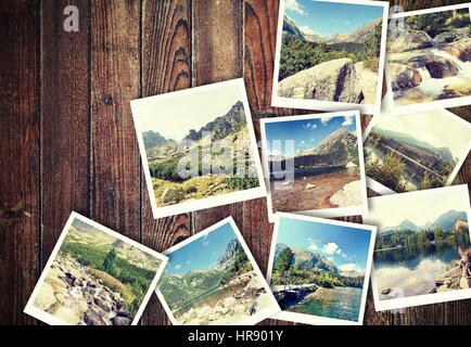 Mucchio di vintage foto dalle vacanze in montagna con un tradizionale telaio bianco posizionato sulla scrivania in legno. Foto Stock