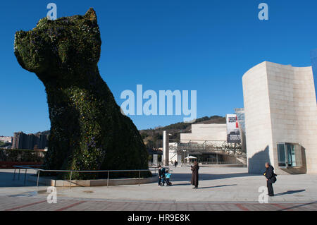 Spagna: il fiore scultura cucciolo, creata nel 1992 da Jeff Koons all'ingresso del Museo Guggenheim Bilbao e dello skyline della città Foto Stock