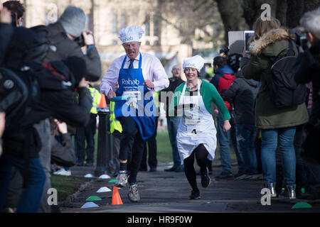 Lord St John di Bletso e MP per Newcastle upon Tyne Nord Catherine McKinnell prendere parte all'annuale Rehab Pancake parlamentare gara in cui MPs, Signori e i membri dei media gara ogni altro su pancake giorno per raccogliere fondi per la riabilitazione di carità, nella torre di Victoria Gardens, Londra. Foto Stock