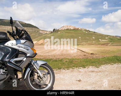 L'Italia, Castelluccio di Norcia - aprile 24, 2015: Motocicle parcheggiata sul progetto di grandi dimensioni dei Monti Sibillini. Il motociclo si trova sul ciglio della strada overloo Foto Stock