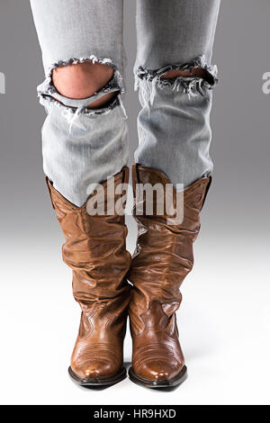 Gambe in jeans e stivali da cowboy Foto Stock