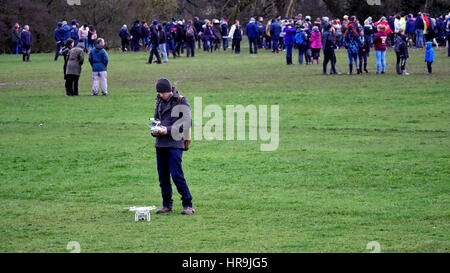 Un drone terre pilota il suo DJI drone dopo un volo è al di sotto della CAA legali limiti di volo sopra la folla durante il Ashbourne Royal Shrovetide Football 28 Feb Foto Stock