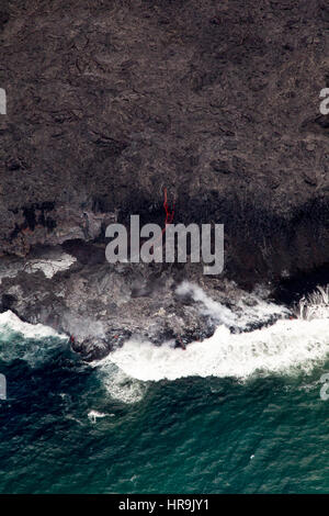 Riprese aeree di rossa lava incandescente che scorre verso il mare sulla costa sud della Grande Isola, Hawaii, Stati Uniti d'America. Foto Stock