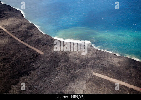 Riprese aeree di rossa lava incandescente che scorre verso il mare sulla costa sud della Grande Isola, Hawaii, Stati Uniti d'America. Foto Stock