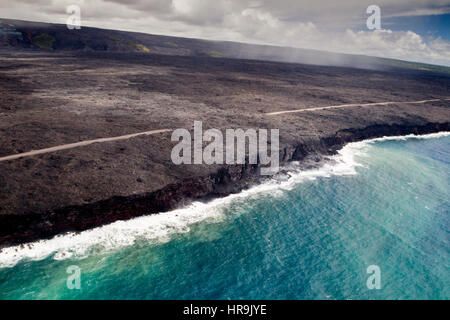 Riprese aeree di rossa lava incandescente che scorre verso il mare sulla costa sud della Grande Isola, Hawaii, Stati Uniti d'America. Foto Stock