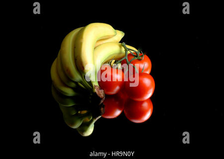 Banane e pomodori sullo specchio di riflessione Foto Stock